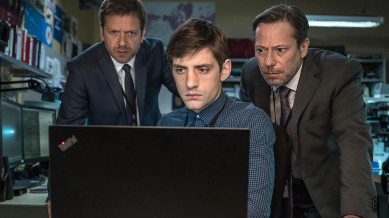 Debailly, Laure, and Duflot gather around a computer.