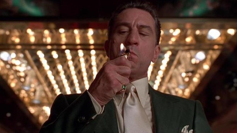 Sam Rothstein stands in a casino and lights a cigarette in "Casino" (1995)