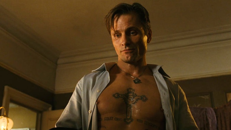 Nikolai stands in his living room with an open shirt in "Eastern Promises" (2007)