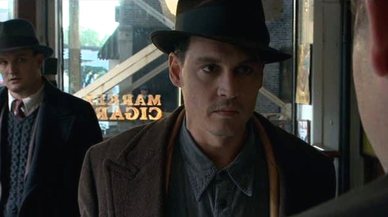 John Dillinger stares down a large man in a cigar shop in "Public Enemies" (2009)