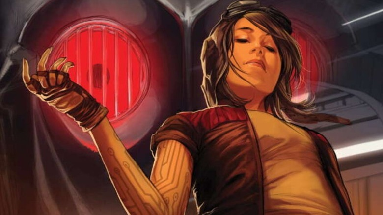 Doctor Aphra standing in front of a huge droid head