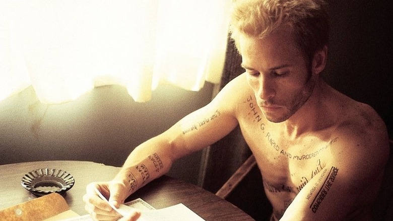Guy Pearce decodes the messages in his tattoos in Memento