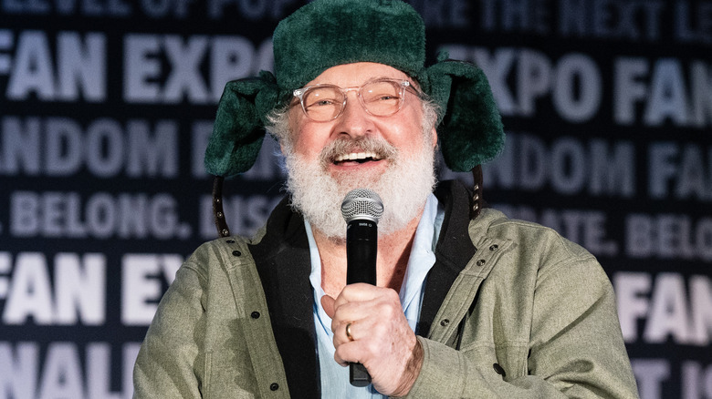 Randy Quaid speaks into microphone