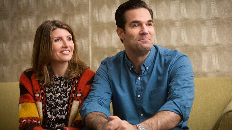 Sharon and Rob on a couch smiling on Catastrophe