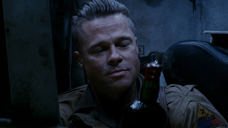 Brad Pitt looks down with scarred face