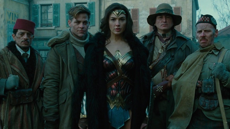 Wonder Woman and the Wonder Men pose in a village