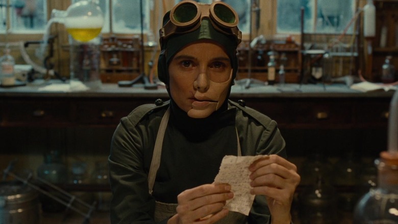 Doctor Poison holds a paper in her hands