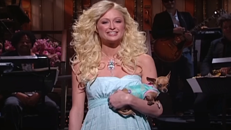 Paris Hilton smiling holding dog