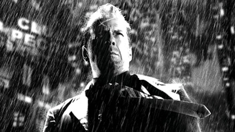 Detective John Hartigan stands in the rain in "Sin City" (2005)