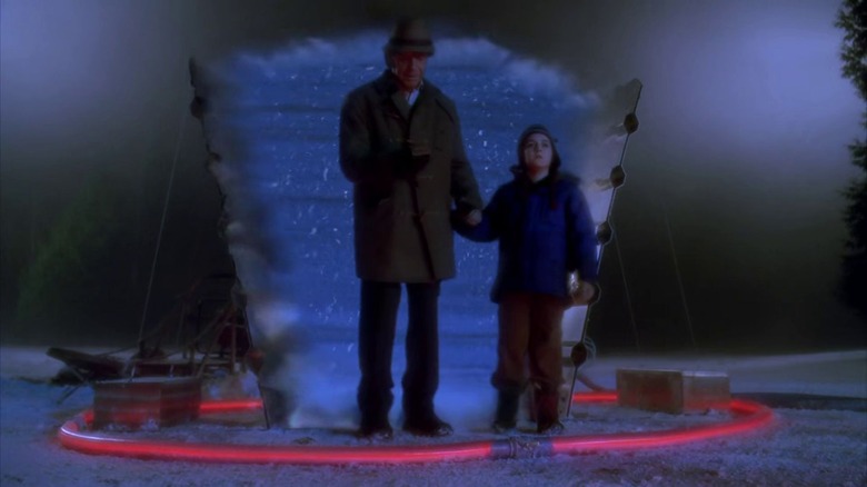 Walter and young Peter standing in front of portal in snow