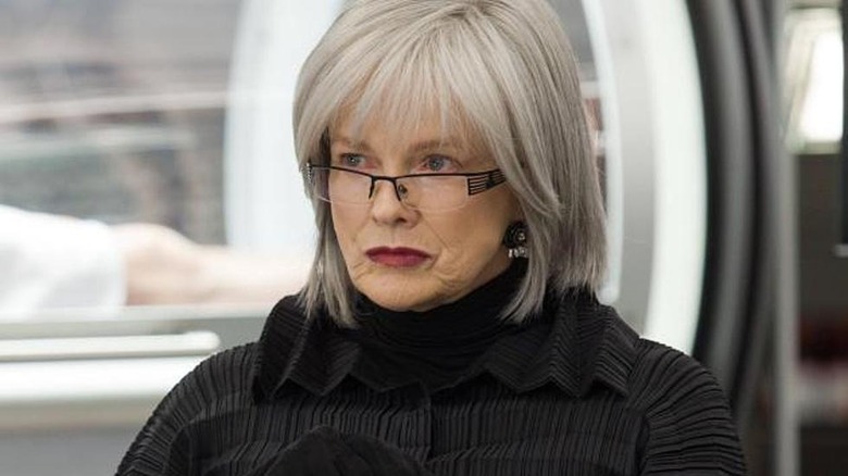 Silver-haired Nina Sharp sitting in lab