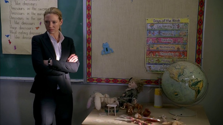 Olivia standing in classroom in black suit 