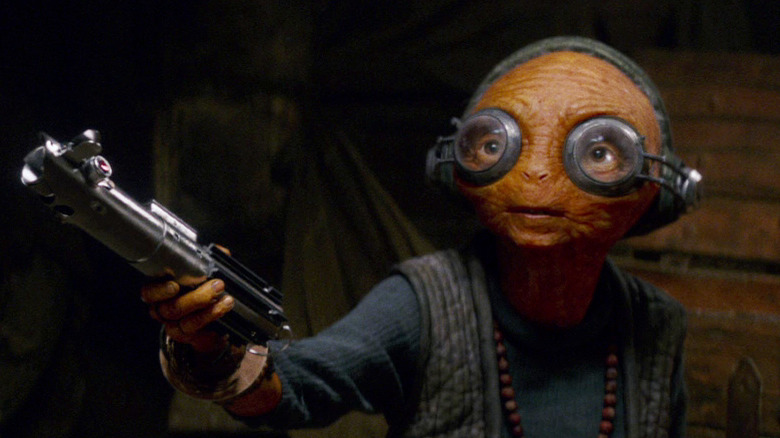 Maz Kanata holding out a lightsaber