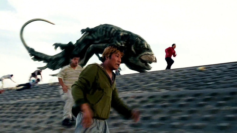 A creature chasing people across a rooftop in The Host (2006)