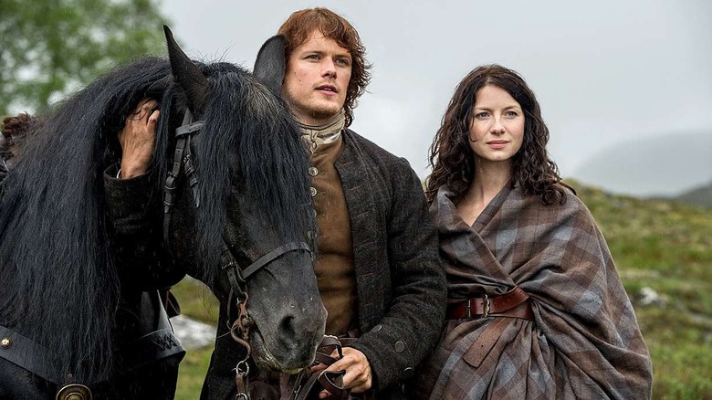 Jamie and Claire with a horse on a hill in Outlander