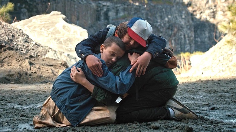 Dustin hugging Mike and Eleven