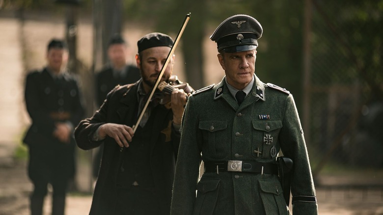 Nazi officer walking past violinist