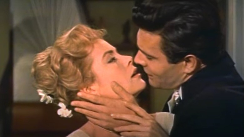 Grace Kelly and Louis Jourdan lean in for a kiss