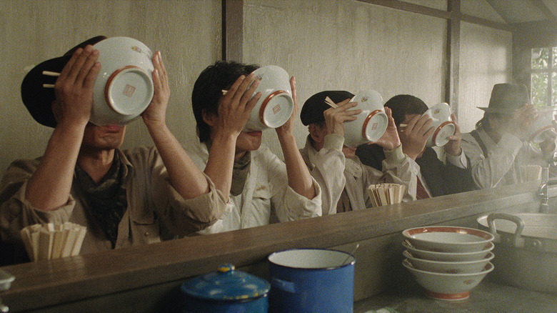 many people eating with bowls 