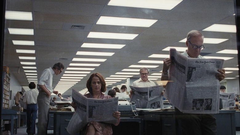 Office workers reading newspaper