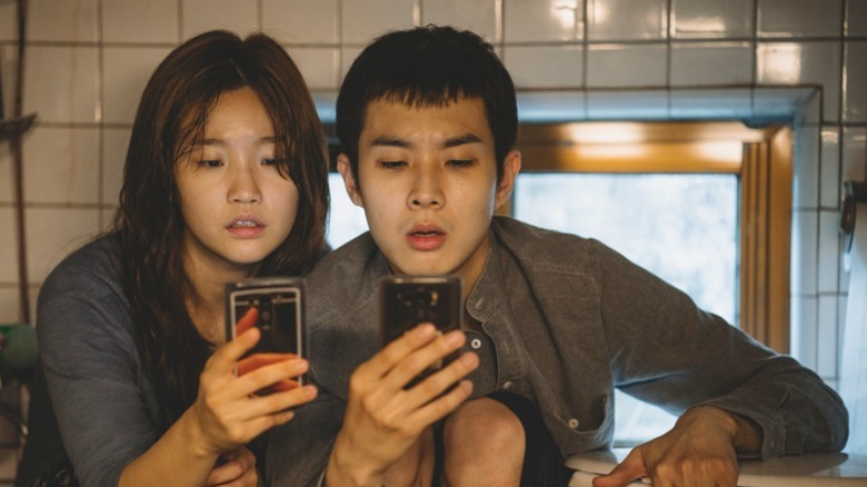 Kim Ki-jung and Kim Ki-woo check phones