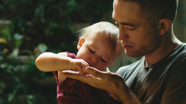 Robert Pattinson holding a baby 