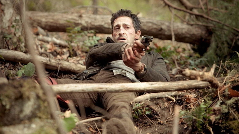 Man laying down holding up gun in Wrecked (2010)