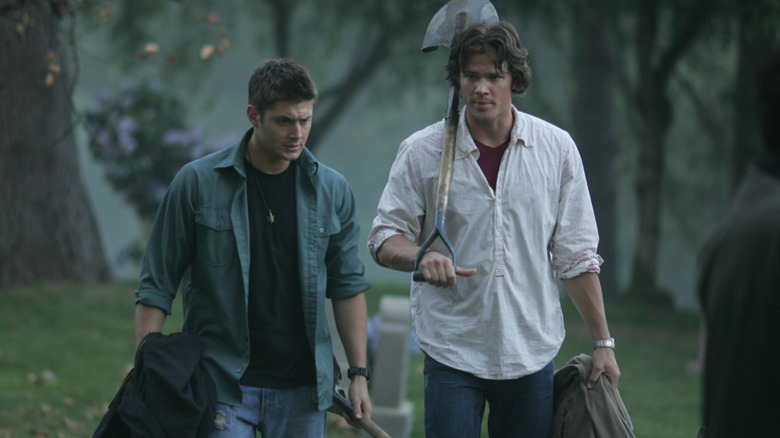 Sam and Dean carry shovels