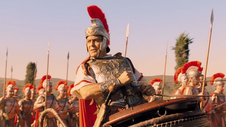 Baird Whitlock in Roman costume riding in carriage