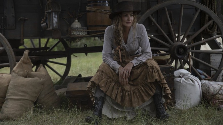 Margaret Dutton sitting by a wagon