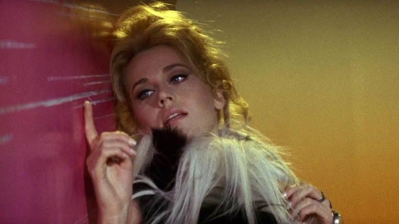 Barbarella leans against wall