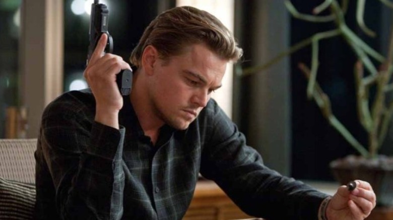 Leonardo DiCaprio holding a gun in Inception