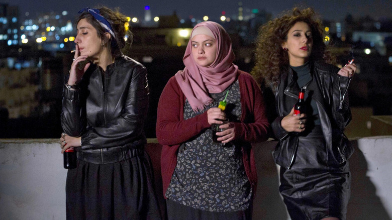 Three girls stand on the roof