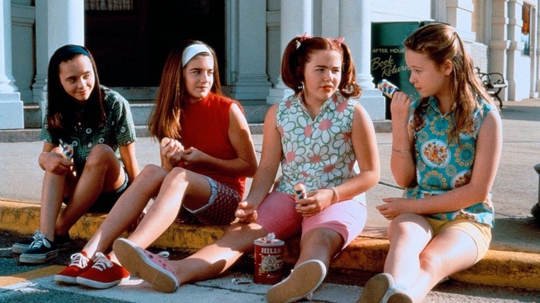 Four young girls sit on a curb