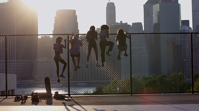 Friends climb a fence