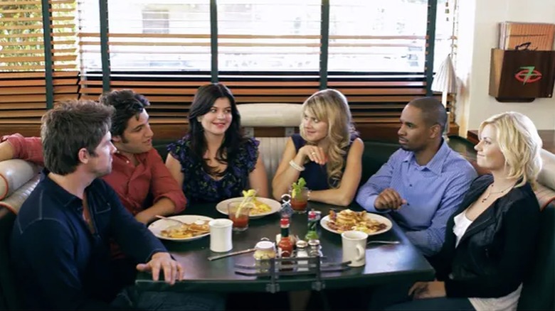 The crew sits in diner booth