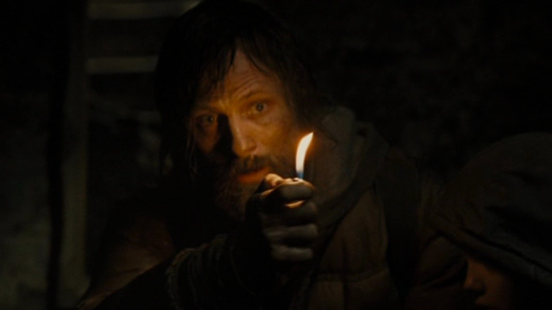Viggo Mortensen holding a lit lighter in the dark
