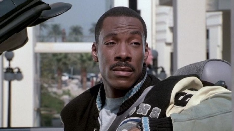 Axel Foley sitting in the front seat of his convertible