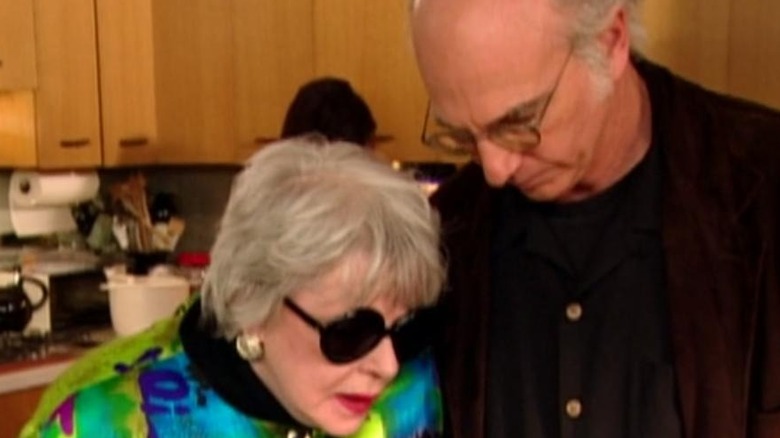 Larry David and woman look down