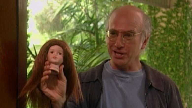 Larry David holds doll head