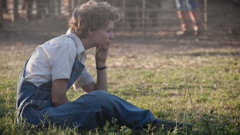 Temple Grandin sitting in grass