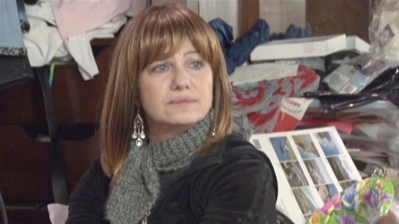 Hoarder stands in her cluttered home