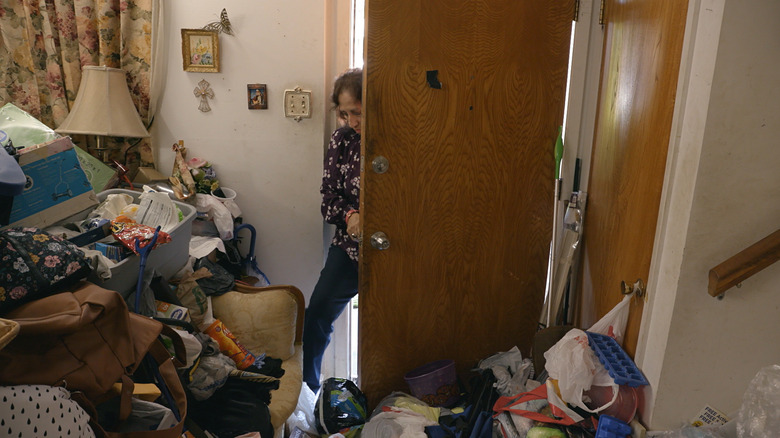 Clutter blocks Martha from opening the door