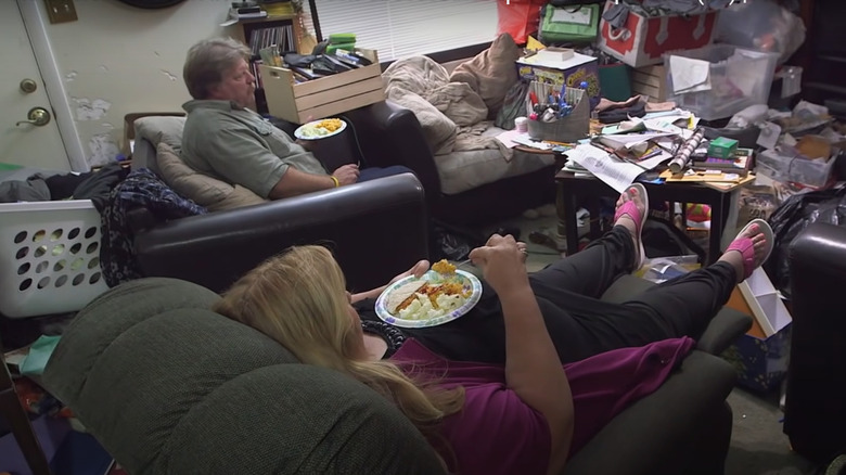 Ed and Connie eat a meal in their hoarded home