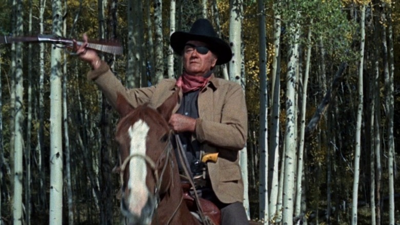 John Wayne on horseback with gun