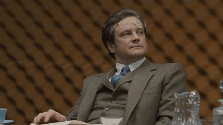 Firth sits at table