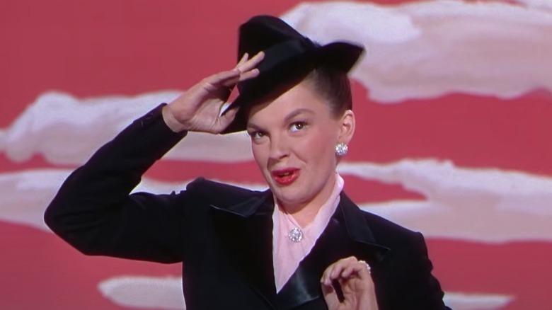 Judy Garland adjusts hat