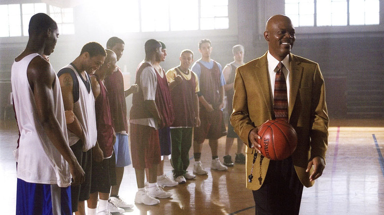 Carter standing in front of team holding basketball