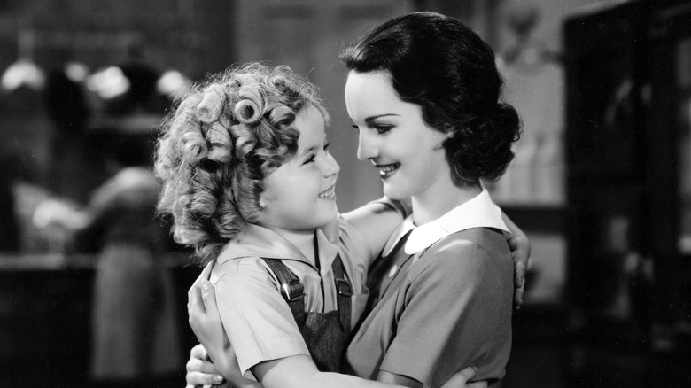 Shirley Temple hugs a woman