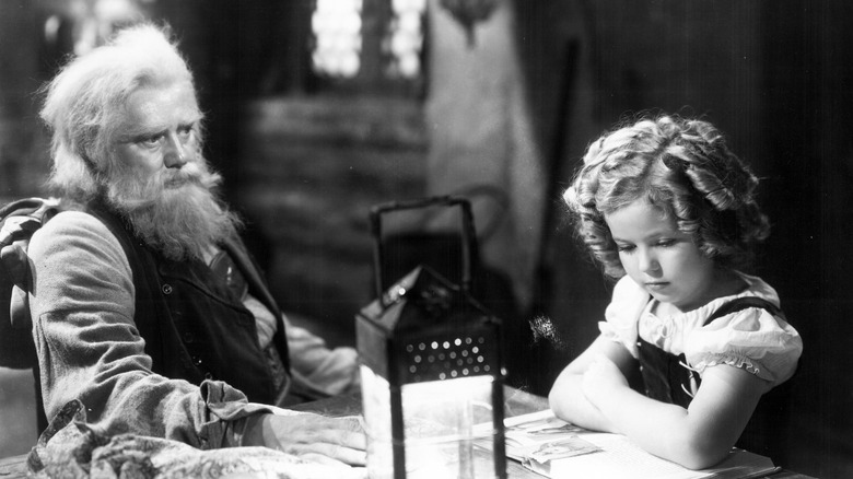 Shirley Temple reads at a table